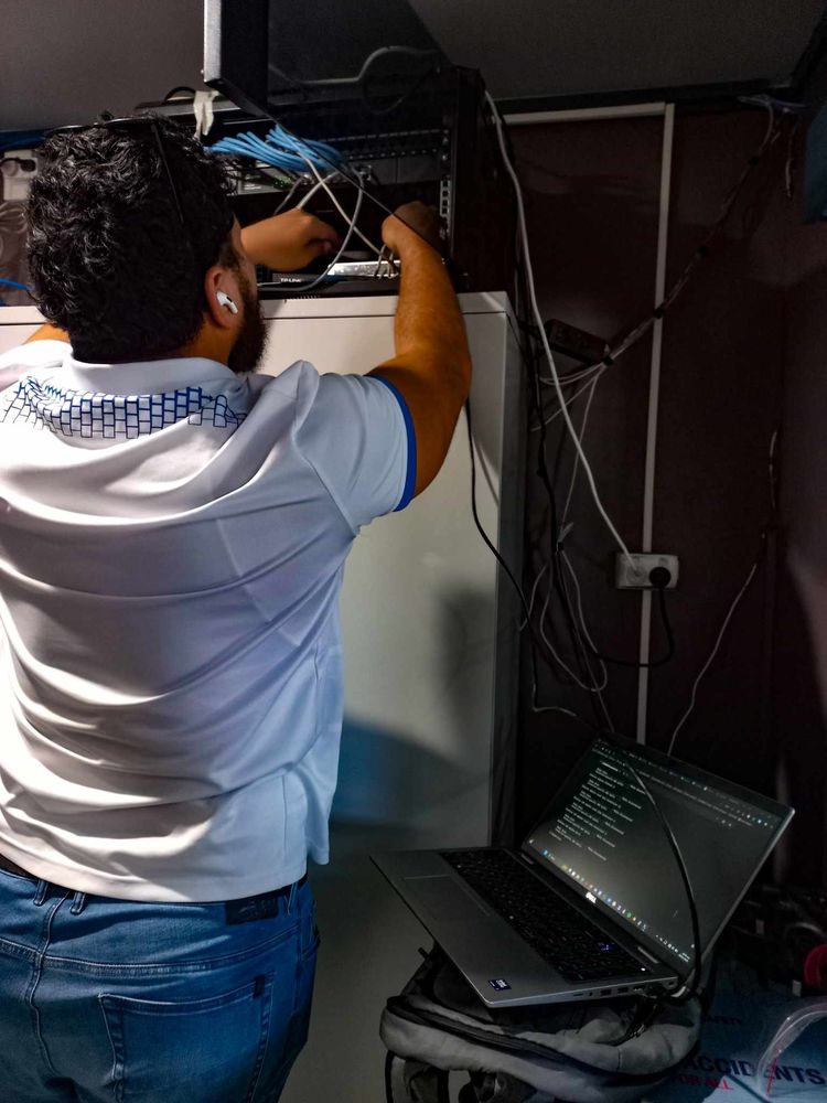 A WanTok technician wiring network equipment in a server rack