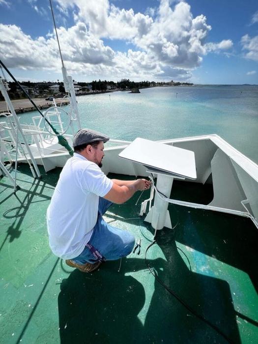 A WanTok technician installing equipment aboard a vessel