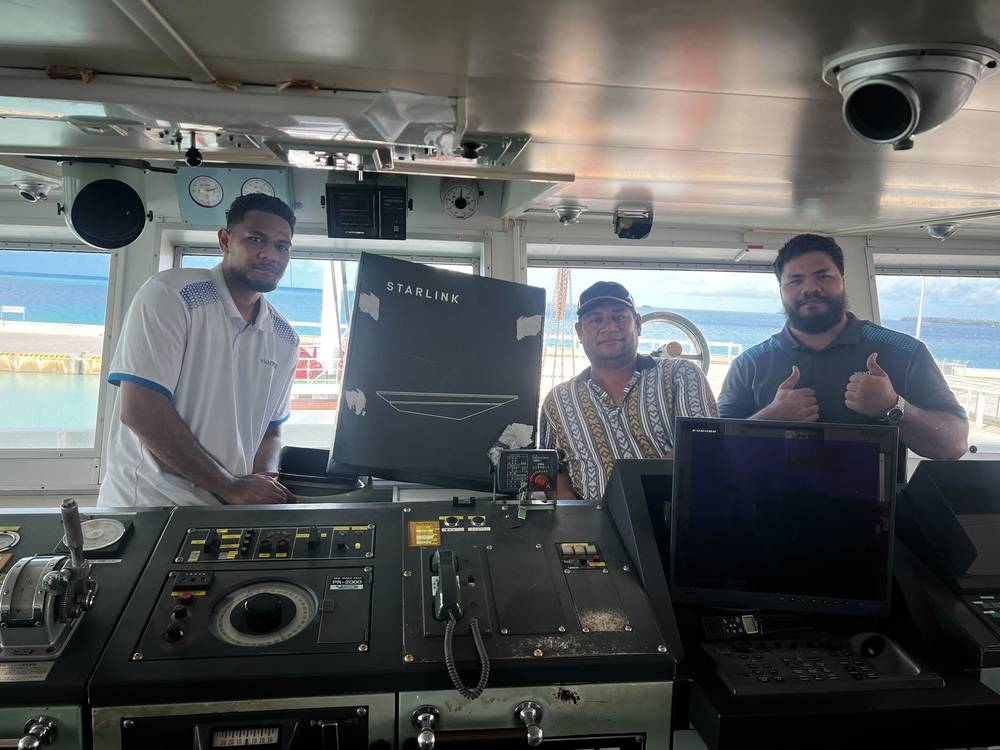 WanTok team members delivering a Starlink kit on a vessel bridge