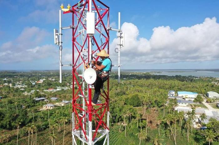 A WanTok engineer servicing equipment high on a tower